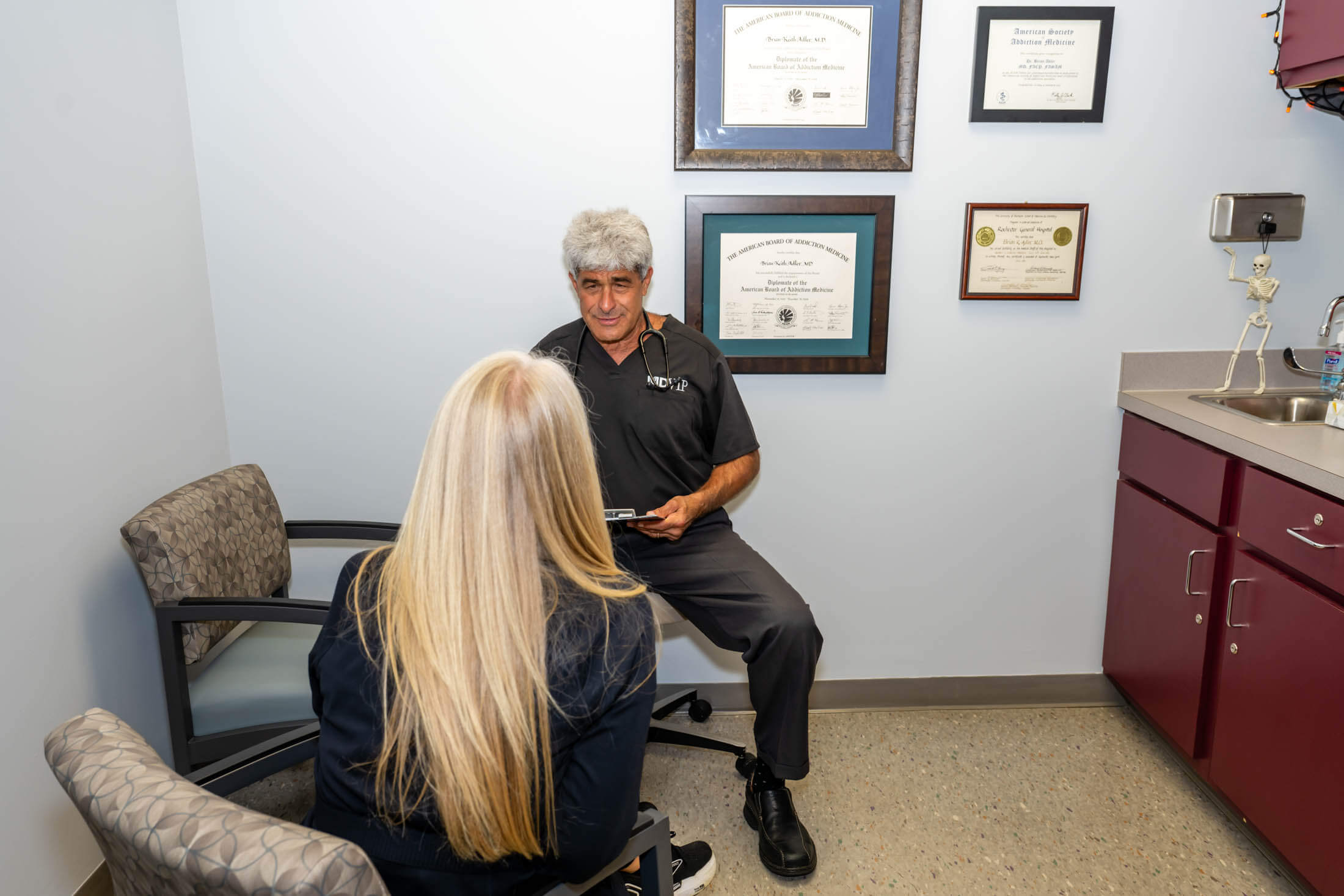 Doctor consulting female patient in exam room